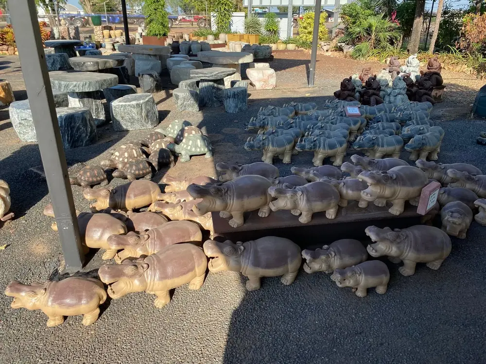 Carved stone pig garden ornaments on display